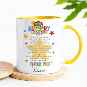 May include: White ceramic mug with a yellow rim and handle. The mug features a colourful design with the text "Nursery Leavers 2023" and a poem about leaving nursery school. The poem concludes with "Thank You Katie".