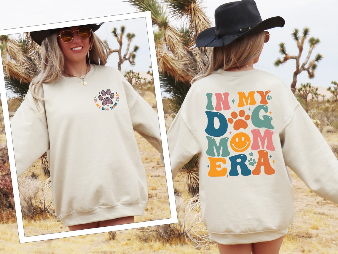 A woman wearing a In My Dog Mom Era Sweatshirt in white.