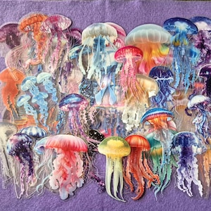Può includere: Una collezione di numerosi adesivi a forma di medusa che presentano un'ampia varietà di colori, tra cui rosa vibrante, viola intenso, arancione brillante, giallo tenue e blu traslucido, con tentacoli dettagliati e corpi a campana.