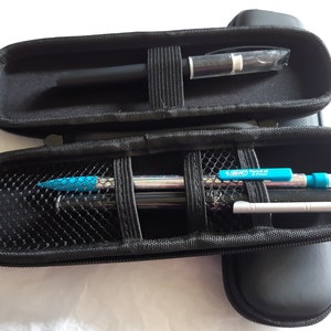 May include: A black zippered case with a mesh interior holds a black pen, a silver pen, and a blue and silver mechanical pencil with the text "BIC Pencil 0.7mm" printed on the side.