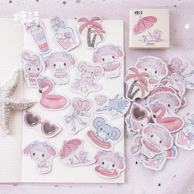 K&ouml;nnte beinhalten: Ein Set mit rosa und wei&szlig;en Aufklebern, die einen Comic-Charakter mit einer rosa Schleife und eine Vielzahl von sommerlichen Designs zeigen, darunter Palmen, Sonnenbrillen und ein Flamingo-Schwimmring.