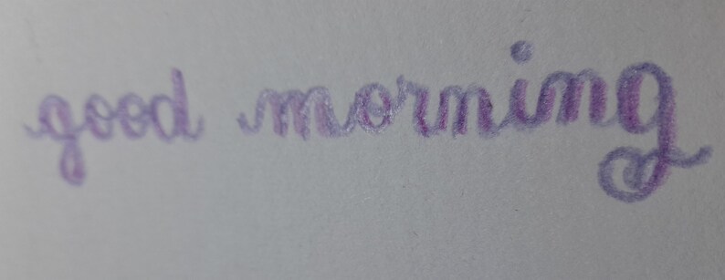Pu&ograve; includere: Messaggio scritto a mano in inchiostro viola che dice "good morning".