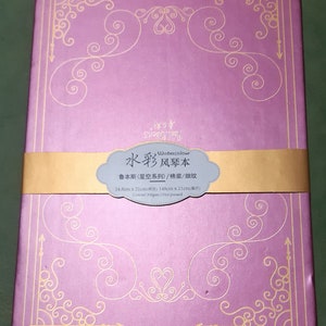 K&ouml;nnte beinhalten: Ein violetter Aquarell-Skizzenblock mit goldener Dekorrand und dem Text "Watercolour 水彩风琴本" auf der Vorderseite. Der Text unter dem Titel lautet "鲁本斯(星空系列)/棉浆/细纹 14.8cm x 21cm(所) 148cm x 21cm(展开) Cotton/300gsm/Hot pressed".