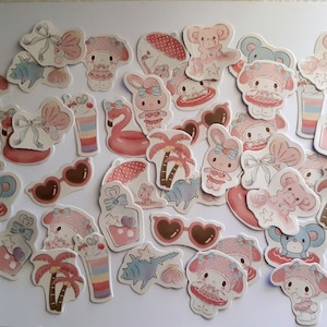 K&ouml;nnte beinhalten: Eine Sammlung von rosa und wei&szlig;en Aufklebern mit Comicfiguren, Palmen, Sonnenbrillen und anderen sommerlichen Designs.