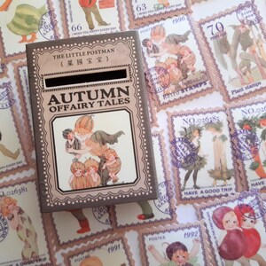 May include: A small wooden box with a slot on top, decorated with a vintage illustration of fairies and pumpkins. The box is labelled "The Little Postman (菜园宝宝)" and "Autumn Offairy Tales".