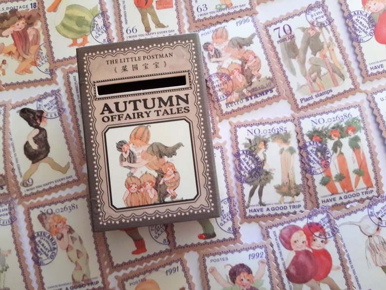 May include: A small wooden box with a slot on top, decorated with a vintage illustration of fairies and pumpkins. The box is labelled "The Little Postman (菜园宝宝)" and "Autumn Offairy Tales".