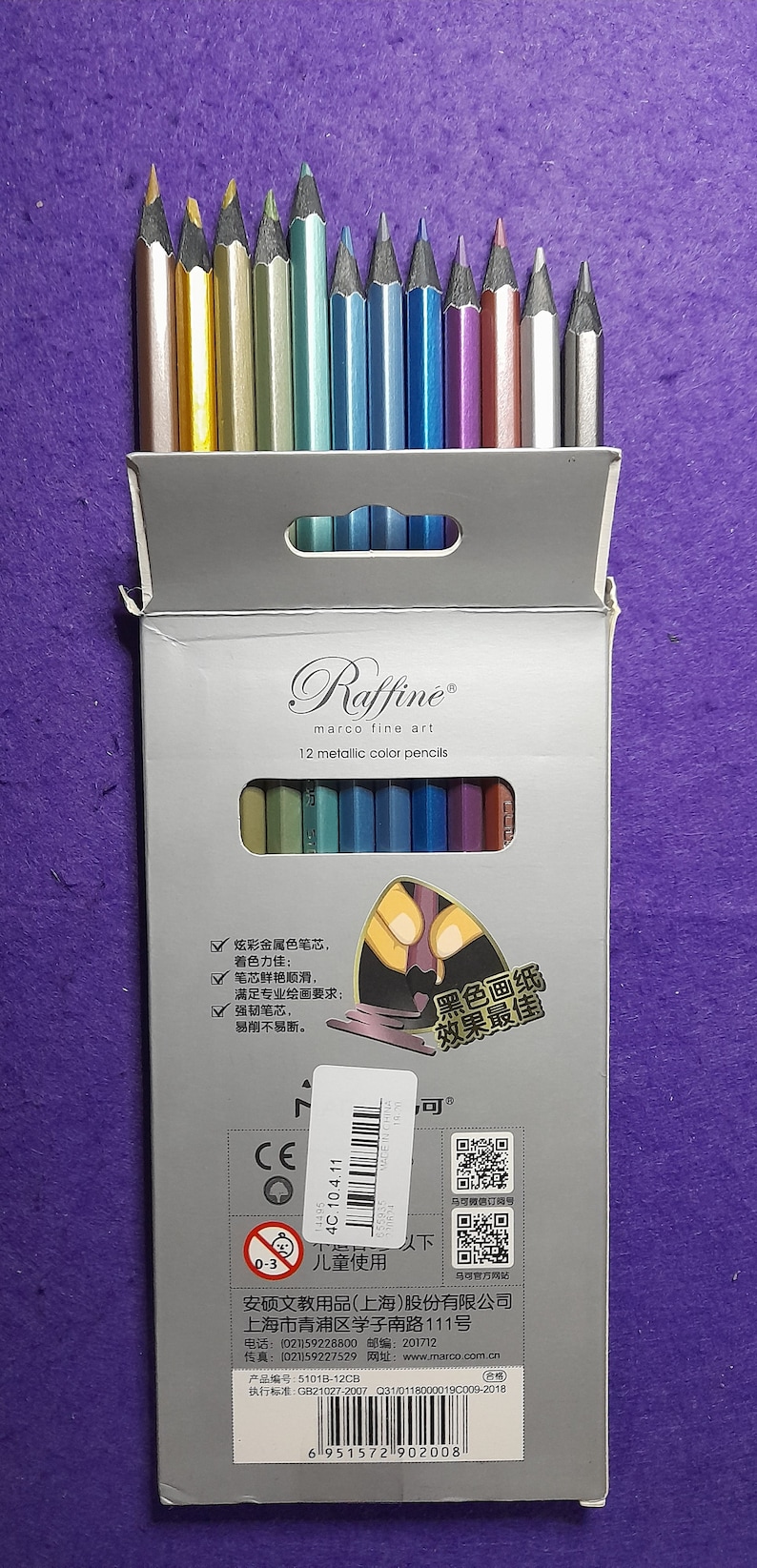 Pu&ograve; includere: Una scatola di 12 matite colorate metalliche del marchio Raffine marco fine art. La scatola &egrave; bianca con un manico argentato e un adesivo bianco e nero con testo cinese. Le matite sono disposte in fila con le punte rivolte verso l'alto. La scatola ha un marchio CE e un codice a barre.