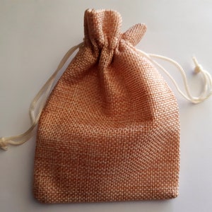 May include: A small, light brown burlap drawstring bag with a white cord.