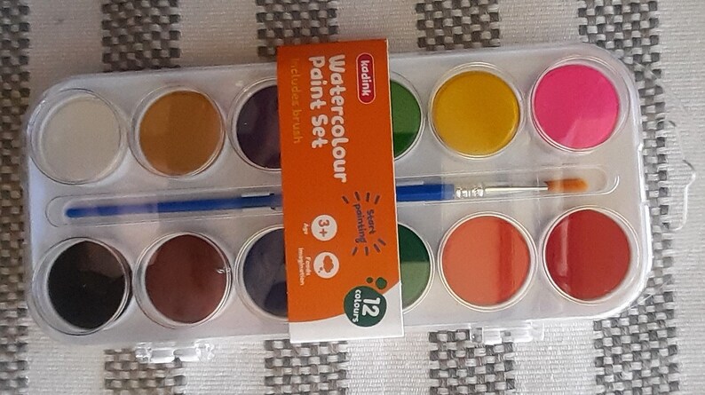 May include: A 12-color watercolor paint set with a brush. The set includes a variety of colors, including red, yellow, blue, green, and brown. The packaging features the text "Watercolour Paint Set" and "12 colours".