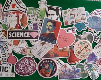 Może przedstawiać: Zbiór naklejek o tematyce naukowej z różnymi wzorami, w tym mózgiem, kolbą, sercem z napisem "SCIENCE" i portretem Nikoli Tesli. Naklejki znajdują się na zielonym tle.