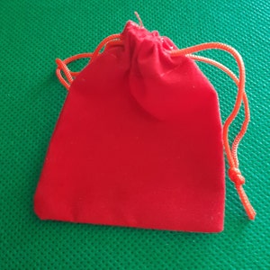 May include: A red velvet drawstring pouch with a red cord.