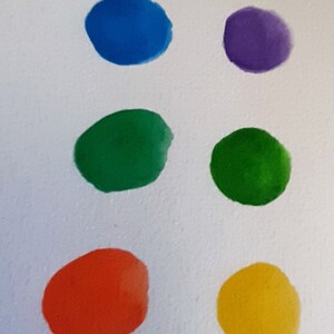 May include: A row of ten colorful paint swatches on a white surface. The swatches are arranged in a vertical line from top to bottom. The colors are black, brown, gold, blue, purple, green, green, orange, yellow, red, and pink.