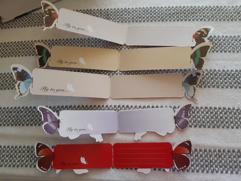 May include: Five colorful butterfly bookmarks with the text "Fly to you..." printed on each. The bookmarks are folded in half and have a blank space for writing.