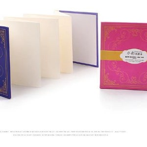 K&ouml;nnte beinhalten: Ein Satz leerer Gru&szlig;karten mit dekorativen Umschl&auml;gen. Die Umschl&auml;ge zeigen ein blaues und goldenes Design mit einem floralen Muster und ein rosafarbenes und goldenes Design mit einem floralen Muster. Der Text auf dem rosafarbenen Umschlag lautet "永生花束", was mit "Ewiger Strau&szlig;" &uuml;bersetzt wird.