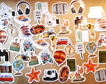 Op de afbeelding: Een verzameling kleurrijke stickers met een reisthema met afbeeldingen van camera's, kompassen, luchtballonnen, koffers, een globe, een scooter, een kaart, een eenrichtingsbord, een Eiffeltoren, een pagode, een zeester, een boot en een vintage bestelwagen.