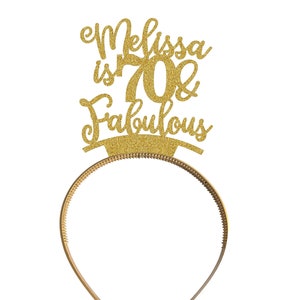 May include: Gold glitter headband with the text "Melissa is 70 & Fabulous" on it.