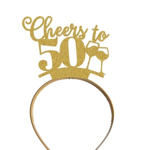 May include: Gold glitter headband with the words "Cheers to 50" and two wine glasses.