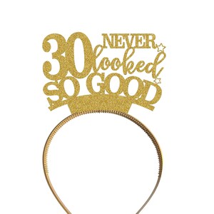 May include: Gold glitter headband with the text "30 Never Looked So Good" and two small stars.