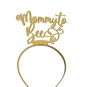 May include: Gold glitter headband with the text "Mommy to Bee" and a bee design.