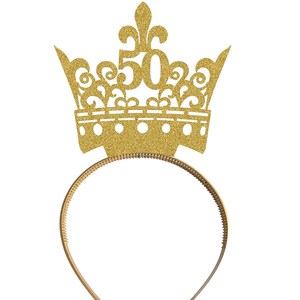 May include: Gold glitter crown headband with the number 50 on top. The headband is made of a gold metal band.
