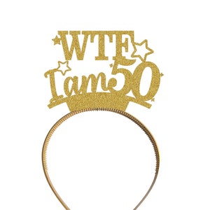 May include: Gold glitter headband with the text "WTF I am 50" on it.