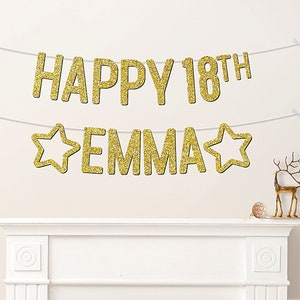 May include: Gold glitter banner with the text "Happy 18th Emma" with two gold glitter stars on either side of the name.