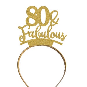 May include: Gold glitter headband with the text "80 & Fabulous" on it.