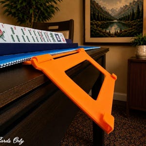Orange foldable 3D printed PLA hands-free mahjong card holder, slim compact footprint ideal for small card tables and tight game setups.