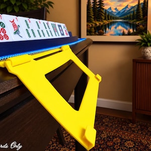 Yellow foldable 3D printed PLA hands-free mahjong card holder, slim compact footprint ideal for small card tables and tight game setups.