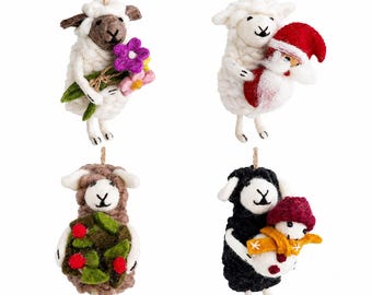 May include: Four felt sheep ornaments hanging by twine. One white sheep holds purple and pink flowers, one white sheep holds a Santa figure, one brown sheep holds green leaves with red berries, and one black sheep holds a small snowman with a scarf.