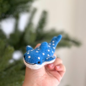 May include: A blue felt whale shark with white spots. The whale shark is a popular ocean animal.