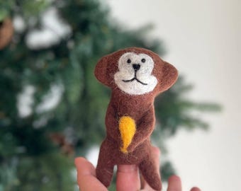 Marioneta de dedo de mono sosteniendo un plátano