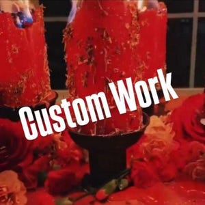 May include: Burning red candles with visible flames, surrounded by red roses and floral arrangements. The text "Custom Work" is overlaid on the image. The candles are in black holders.