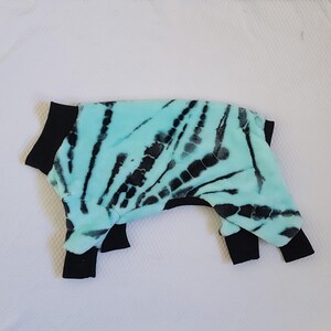 May include: A blue and black tie-dye dog sweater with black trim around the neck and legs.
