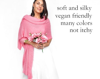 Könnte beinhalten: Ein leuchtend rosa gestrickter Schal mit weicher, strukturierter Optik, der über die Schultern drapiert ist. Der Text auf der rechten Seite lautet: soft and silky, vegan friendly, many colors, not itchy. Der Schal wird mit einem weißen Kleidungsstück kombiniert.
