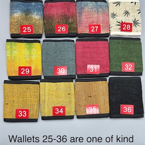Może przedstawiać: Kolekcja 12 portfeli z konopi w r&oacute;żnych kolorach i wzorach, w tym tie-dye, jednokolorowe i z wzorem liści. Portfele są ponumerowane od 25 do 36 i opisane jako "unikalne".