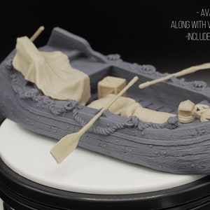 May include: A detailed 28mm scale model of a fishing barge with oars, a lantern, and other accessories. The barge is made of gray plastic and has a wooden texture. The text "FISHING BARGE (28MM SCALE)" is visible in the image.