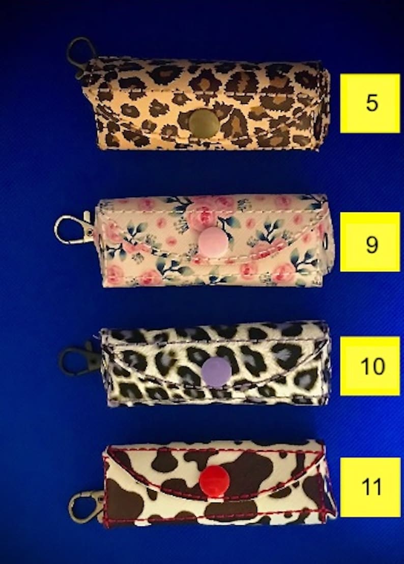 May include: Four different keychains with various patterns. The keychains are made of fabric and have a metal ring. The patterns include leopard print, floral, cow print, and another leopard print. The keychains are numbered 5, 9, 10, and 11.