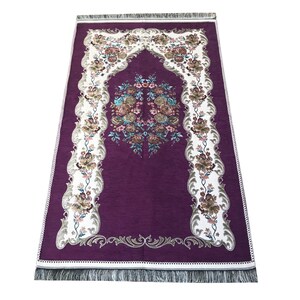 May include: A purple prayer rug with a white floral design and a decorative border. The rug has a fringe on all sides.