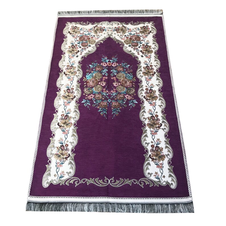 May include: A purple prayer rug with a white floral design and a decorative border. The rug has a fringe on all sides.