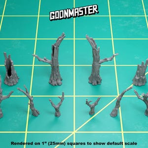 May include: A collection of gray miniature tree models with various shapes and sizes, including some with broken trunks and branches. The models are arranged on a green grid surface. The text "GOONMASTER" is displayed at the top, and "Rendered on 1" (25mm) squares to show default scale" is at the bottom.