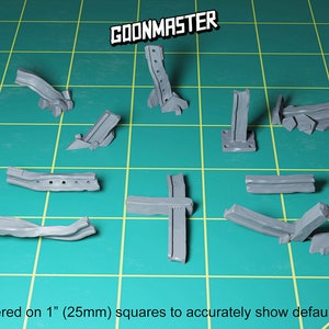 May include: A set of nine grey plastic model pieces, resembling broken metal beams and supports. The pieces are arranged on a green cutting mat, with the text "GOONMASTER" visible in the top center of the image. The image is labeled "Rendered on 1" (25mm) squares to accurately show default scale".