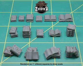 May include: A collection of miniature gray books in various sizes and styles, including closed, open, and stacked. The books are arranged on a green grid surface. The text "Rendered on 1" (25mm) squares to show scale" is visible.