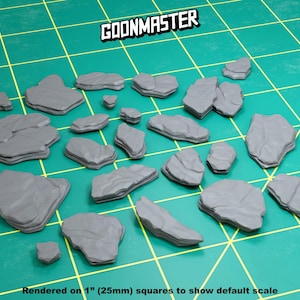 May include: A collection of 20 gray, textured, irregularly shaped rock formations, rendered on 1-inch squares to show scale.  The rocks are ideal for tabletop gaming or miniature scenery.