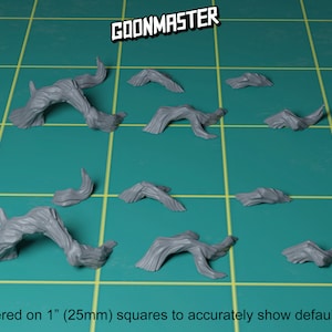 May include: A set of nine grey resin miniature tree roots, perfect for adding detail to a tabletop game or miniature scene. The roots are rendered on 1" (25mm) squares to show scale.