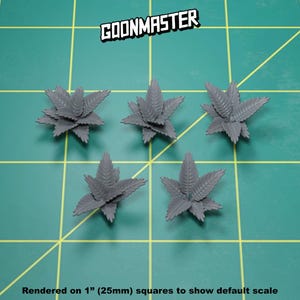 May include: Five gray plastic miniature plants, each with a different arrangement of leaves, are displayed on a green grid surface. The plants are approximately 1 inch (25 mm) in size. The text "GOONMASTER" is visible in the upper center of the image. The text "Rendered on 1" (25mm) squares to show default scale" is visible at the bottom of the image.