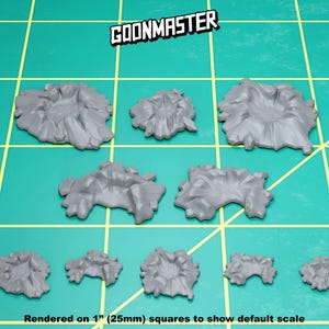 May include: A set of nine grey plastic crater terrain pieces, rendered on 1" (25mm) squares to show default scale.  The craters range in size and shape, with some having a more defined rim than others.