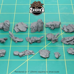 May include: A set of 14 grey resin rock formations, rendered on 1 inch (25mm) squares to show scale. The rocks are various shapes and sizes, perfect for tabletop gaming or miniature scenery.
