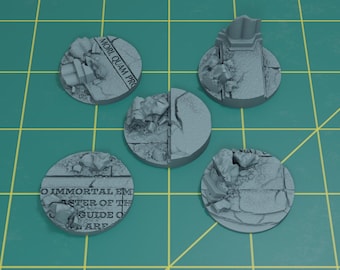 May include: Five gray, circular miniature bases with a cracked stone texture. Some bases feature architectural elements and text. The bases are arranged on a green grid.
