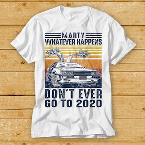 May include: White t-shirt featuring a vintage-style graphic of the DeLorean time machine from the film Back to the Future. The graphic includes the text "Marty Whatever Happens Don't Ever Go To 2020".